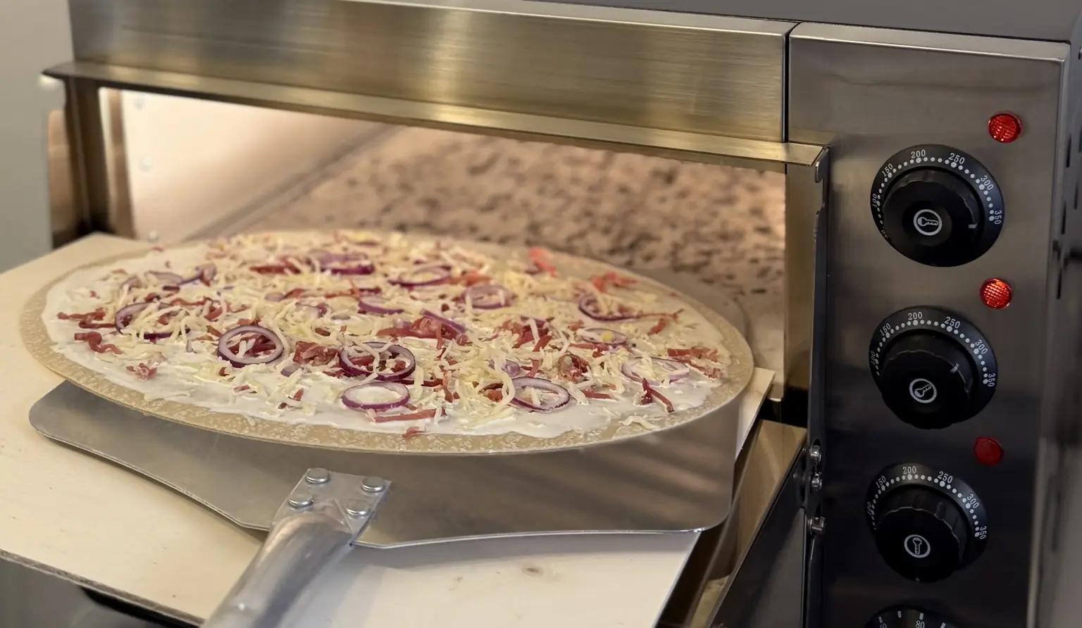 Frisch belegter Flammkuchen wird direkt vor Ort im Ofen gebacken